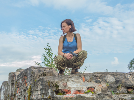 the girl with the pistol on the concrete the wall.の写真素材