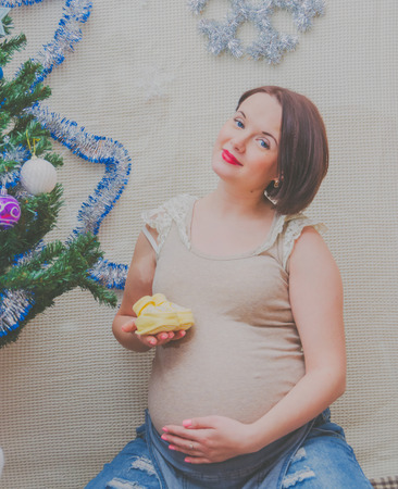 with baby booties in hand, the pregnant girlの写真素材