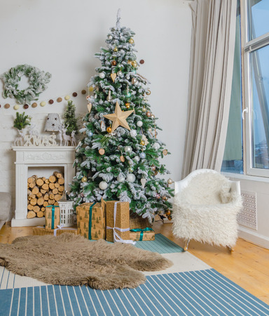 living room in Christmas style with a decorated Christmas tree and a fireplaceの写真素材