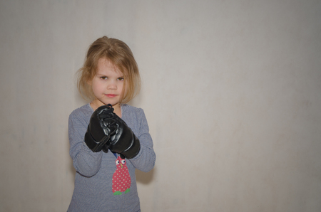 a child, a girl in gloves for hand-to-hand combat in a fighting rackの写真素材