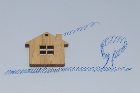 on white background wooden house with painted grass, wood and smoke from pipeの写真素材