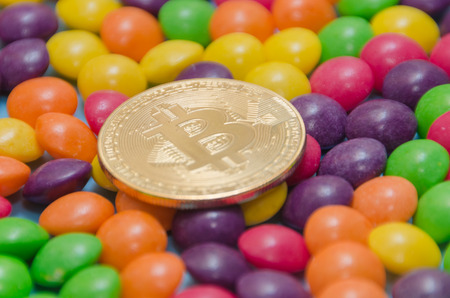 on a blue background, gold cryptocurrency bitcoin is on the candy, caramel