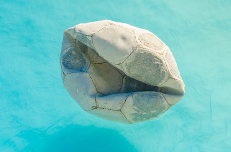old ragged ball in the water on a Sunny summer dayの写真素材