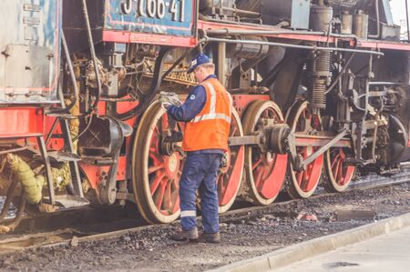 Russia, St. Petersburg September 16, 2017-worker, assistant, locomotive driver washes wheels, repairsのeditorial素材