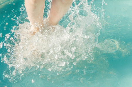 close-up, baby feet in the water in a jump sprayの写真素材