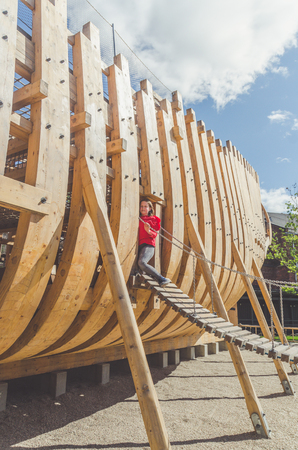a child, a girl on a wooden Playground in the form of a pirate ship