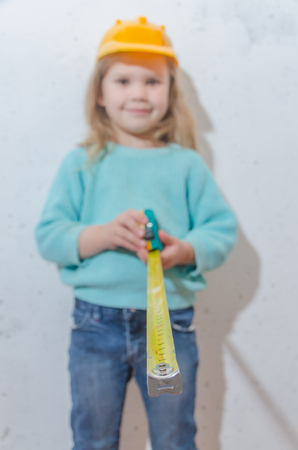 child worker, Builder, girl in a helmet measures the distance with a tape measureの写真素材