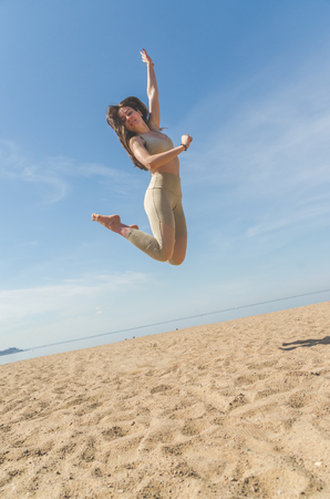 girl on the beach jumping on a Sunny dayの写真素材