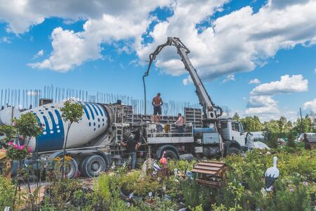Russia, Leningrad oblast, the city of Nikolskoye, 08 Aug 2018 -construction, cement pouring with machine into the frame of the house, worker, manのeditorial素材