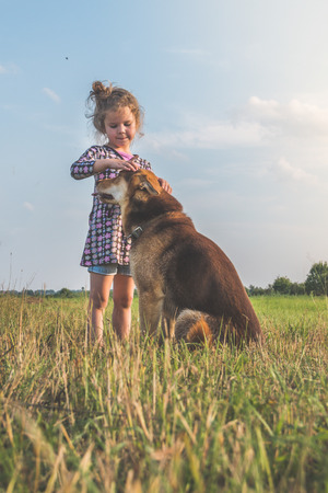 A little girl walking her dog on a sunny day.の写真素材