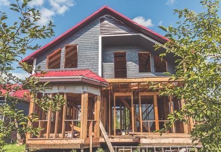 summer Sunny day frame wooden house with a roof made of metal and openings for Windowsのeditorial素材