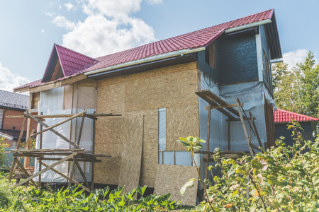 summer Sunny day frame wooden house with a roof made of metal and openings for Windowsのeditorial素材