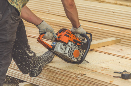 man chainsaw sawing boards, outdoorの写真素材