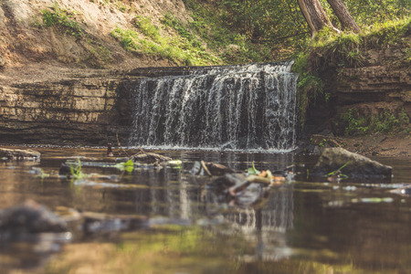 forest on a mountain river waterfall from a rockの写真素材