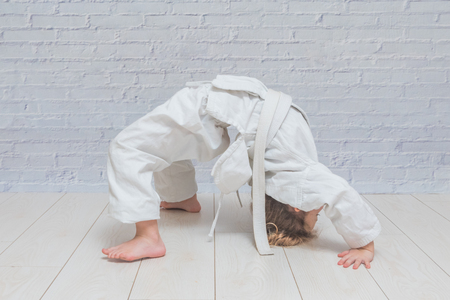 the girl, a child in a kimono on karate training works out blows and greetingの写真素材