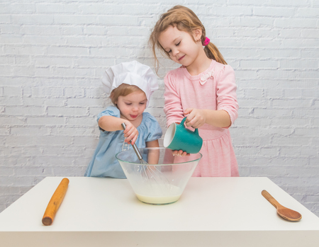 the girl cook baby cooking in the kitchen bakingの写真素材
