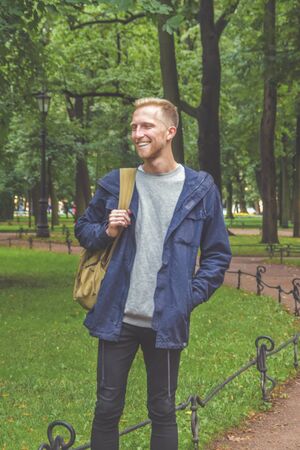 the young man with a beard in a Park among the trees