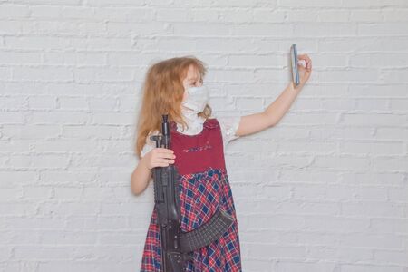 the girl with a gun and a mask on her face during the epidemicの写真素材