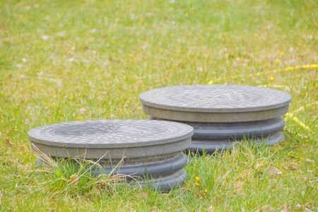 the cover sewer in the grass on the garden plotの写真素材