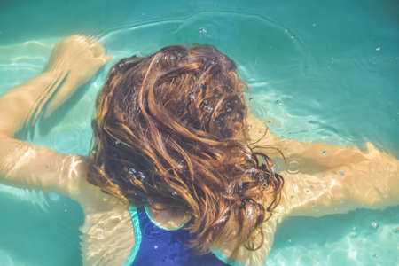 a girl child is splashing in the pool on the streetの写真素材