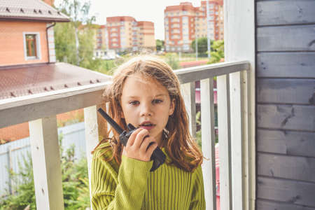 a girl child is talking on the radio on a sunny summer dayの写真素材