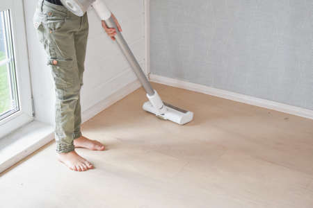 the child girl does vacuuming in the house photo without processingの写真素材