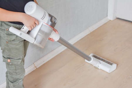 the child girl does vacuuming in the house photo without processingの写真素材