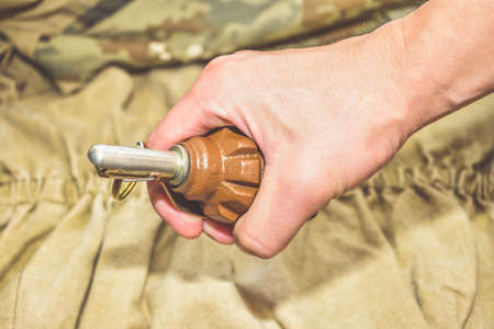 a hand grenade on camouflage background close upの写真素材