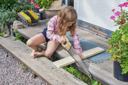 a child girl has damaged a bicycle wheel and is making repairs photo without processingの写真素材
