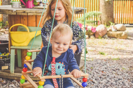 a happy baby boy on a swing outsideの写真素材