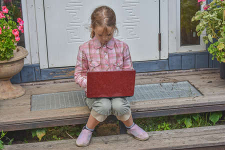 a girl child with a djembe drum outdoor on the porch of the house photo without processingの写真素材
