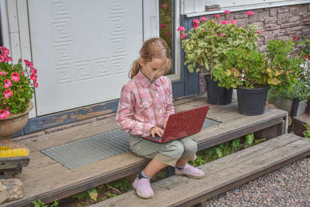 a girl child with a djembe drum outdoor on the porch of the house photo without processingの写真素材