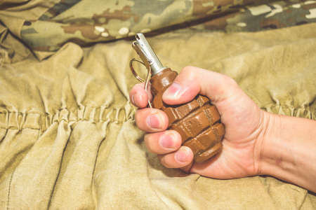 a hand grenade on camouflage background close upの写真素材