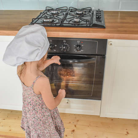 girl child cooks pizza in the oven photo without filterの写真素材