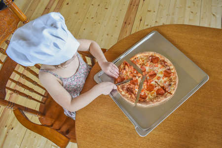 girl child cooks pizza in the oven photo without filterの写真素材