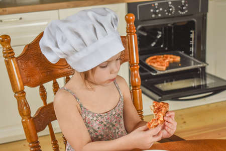 girl child cooks pizza in the oven photo without filterの写真素材