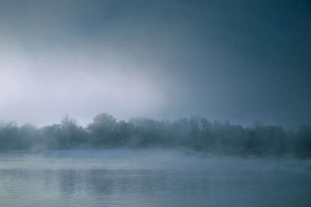 Dramatic river with fog at sunrise with terrible coastの写真素材