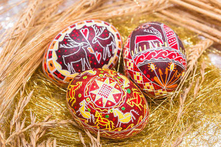 Three red Easter eggs with wheatの写真素材