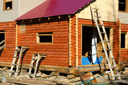 Construction of the facade of a new house made of pine timber with stairs leaning against the walls and Windows in Yakutia.の写真素材