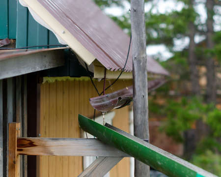 Rainwater flows from the roof into the gutter and collects in the gutter further in the village house. Collect drinking water of the Northern peoples of Yakutia.の写真素材