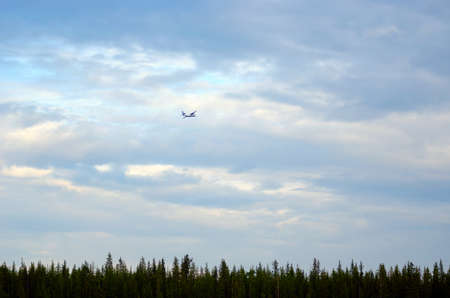 Passenger plane takes off in the sky over a strip of spruce taiga in the far North of Yakutia.の写真素材