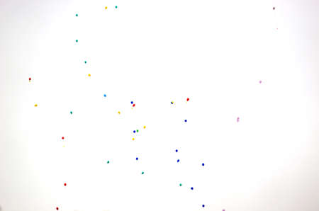 Multicolored gel balloons blue, red, green, pink and yellow fly in the sky against the sun for the celebration.の写真素材