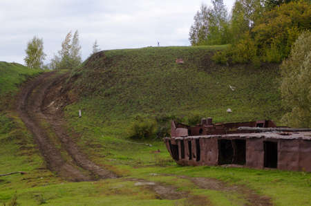 Abandoned part of the rusty iron ship - the rest of the industry of the Soviet Union in the wild forests of the tundra of Yakutia lies by the road.の写真素材