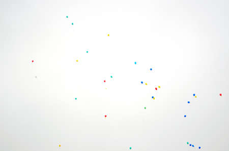 Multi-colored gel balloons blue, red, green and yellow fly in the sky against the sun on holiday.の写真素材