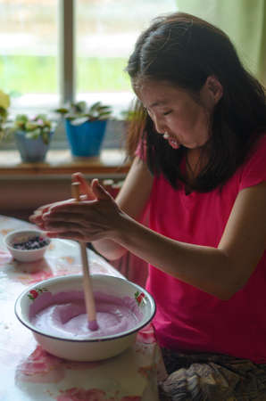 Yakut Asian girl is busy making the national dessert of cream and jam kerteh.の写真素材
