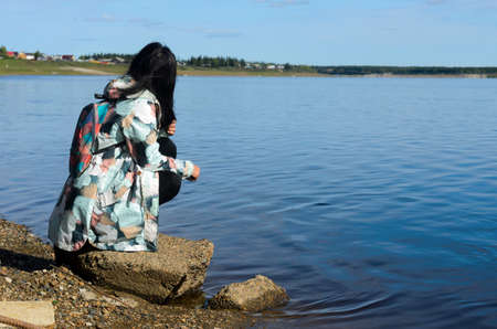 Modern sad girl Yakut looks at the village of ulus Suntar near the river vilyu contaminated with waste from diamond production in the North of Russia in Yakutia.の写真素材
