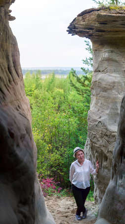 Yakut girl stands at the sights-errosionnoy landforms sand mushroom on the background of the Northern forest of Yakutia.の写真素材
