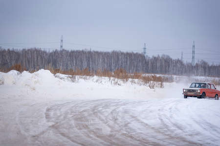 Russia, Novosibirsk - November 30, 2019. Russian red low old car VAZ Zhiguli goes fast sideways in...