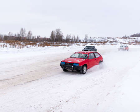 Russia, Novosibirsk - November 30, 2019. Russian old rally red car "Lada" with a sports license plate quickly goes on the road away from the turn leaving from other cars.のeditorial素材