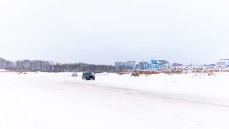 Russia, Novosibirsk - November 30, 2019. Russian dark old low car "VAZ Zhiguli" quickly goes sideways in the drift on the road leaving from another car.のeditorial素材